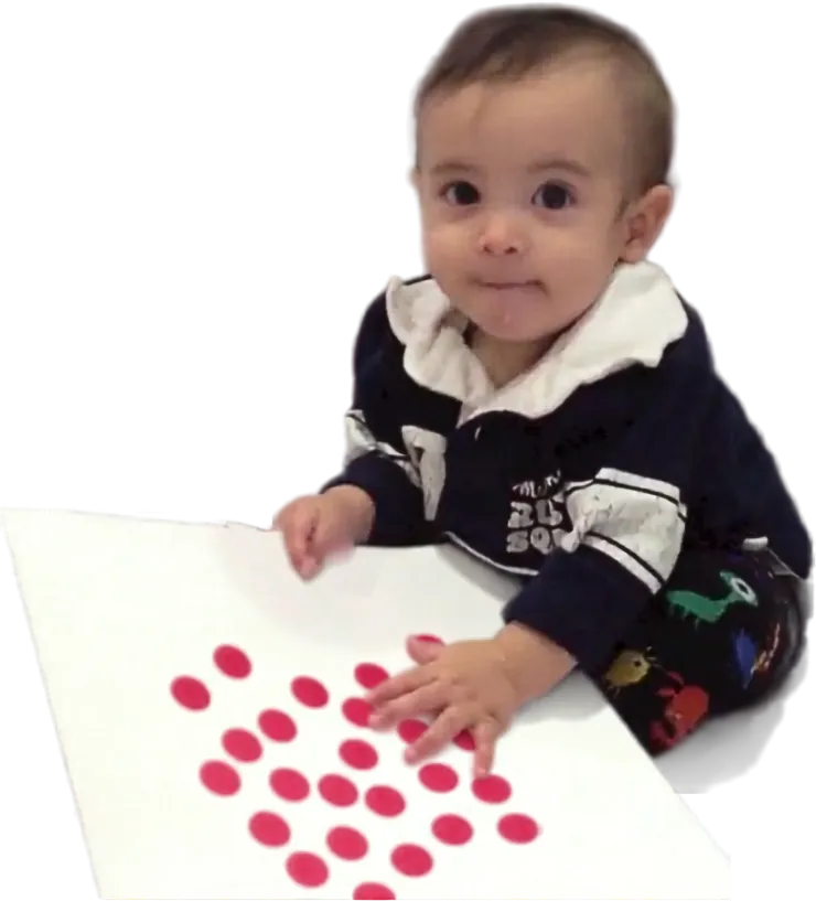 Ian de bebé tocando una tarjeta de puntos rojos